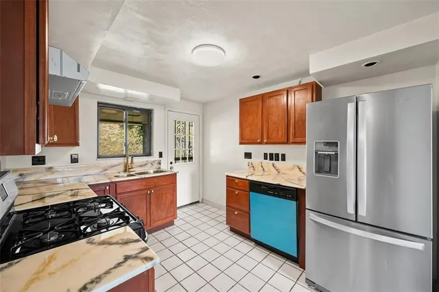 a kitchen with stainless steel appliances granite countertop a refrigerator and a sink