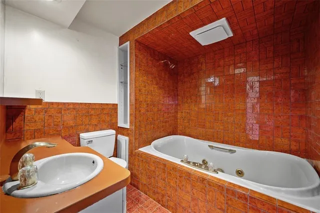 a bathroom with a tub sink and mirror