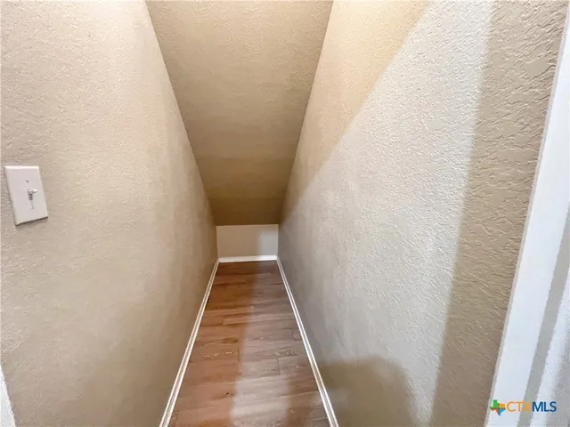a view of a hallway with wooden floor