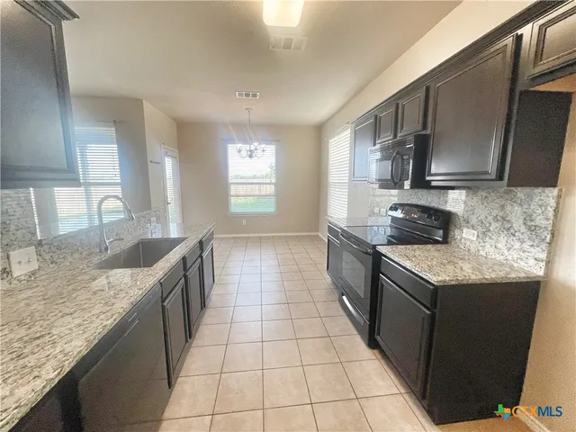 a kitchen with stainless steel appliances granite countertop a sink stove and cabinets