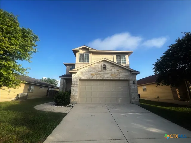 a front view of a house with a yard and garage
