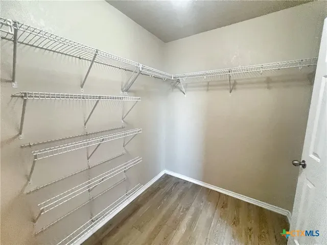 a view of walk in closet with empty racks