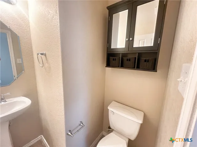a white toilet sitting next to a bathroom sink