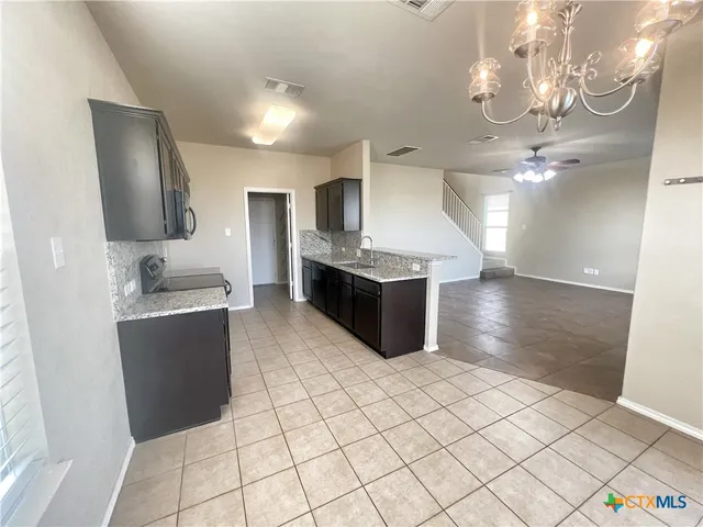 a large kitchen with a large counter top and stainless steel appliances