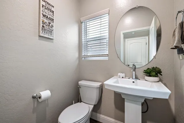 a bathroom with a toilet a sink and mirror