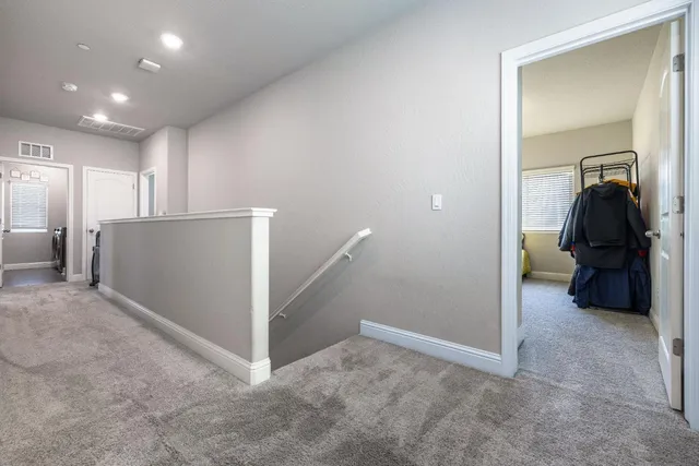 a view of a hallway with closet and a bathroom