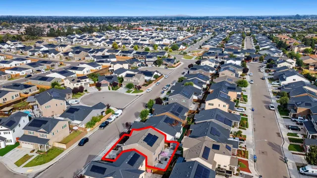 an aerial view of residential houses with outdoor space and parking