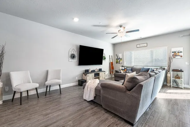 a living room with furniture a flat screen tv and wooden floor