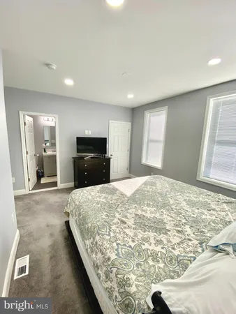 a large bedroom with a bed and a large window