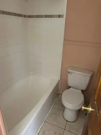 a white toilet sitting next to a bath tub