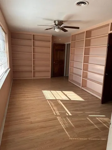 a view of a room with a wooden floor and white doors