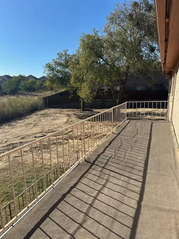 a view of balcony with wooden floor and fence