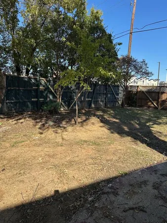 a view of a yard with wooden fence