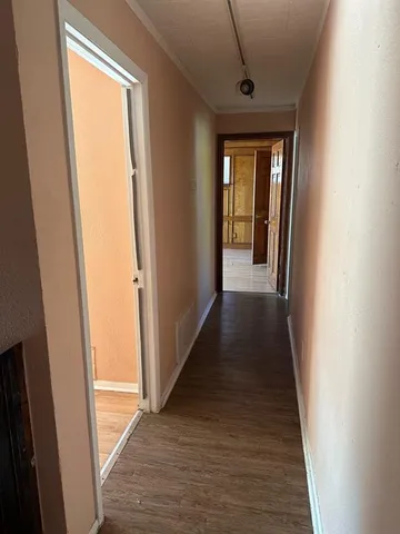 a view of a hallway with wooden floor and staircase