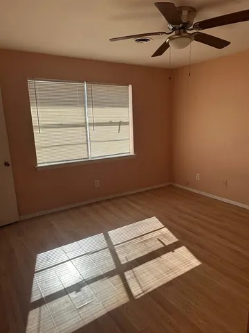 a view of a room with wooden floor and windows
