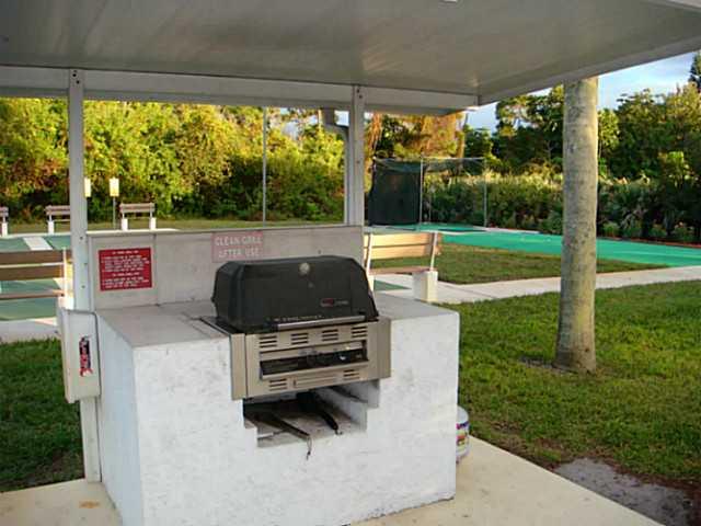 2950 Southeast Ocean Boulevard, Unit 1357 Stuart, FL 34996 - Photo 21 of 25 a view of backyard with couches under an umbrella
