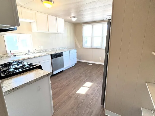 a kitchen with a stove a sink and a window