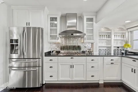 a kitchen with granite countertop white cabinets and white appliances