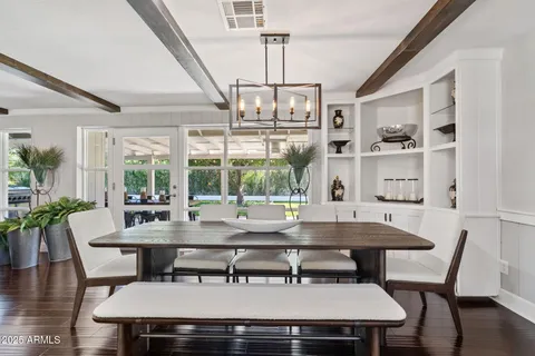 a living room with furniture a chandelier and kitchen view