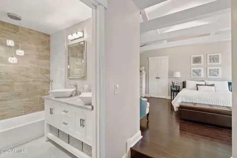 a bathroom with a granite countertop sink a mirror a bathtub and shower