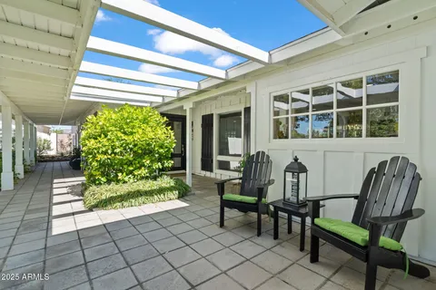 a view of a porch with chairs and a yard