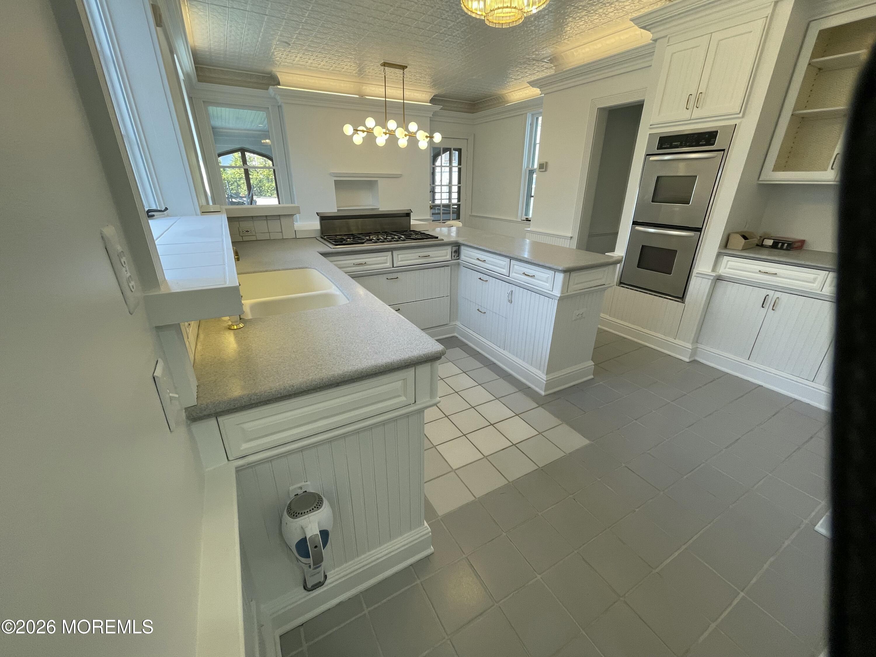 211 Cedar Avenue Allenhurst, NJ 07711 - Photo 12 of 20 a kitchen with stainless steel appliances granite countertop a sink and a stove top oven