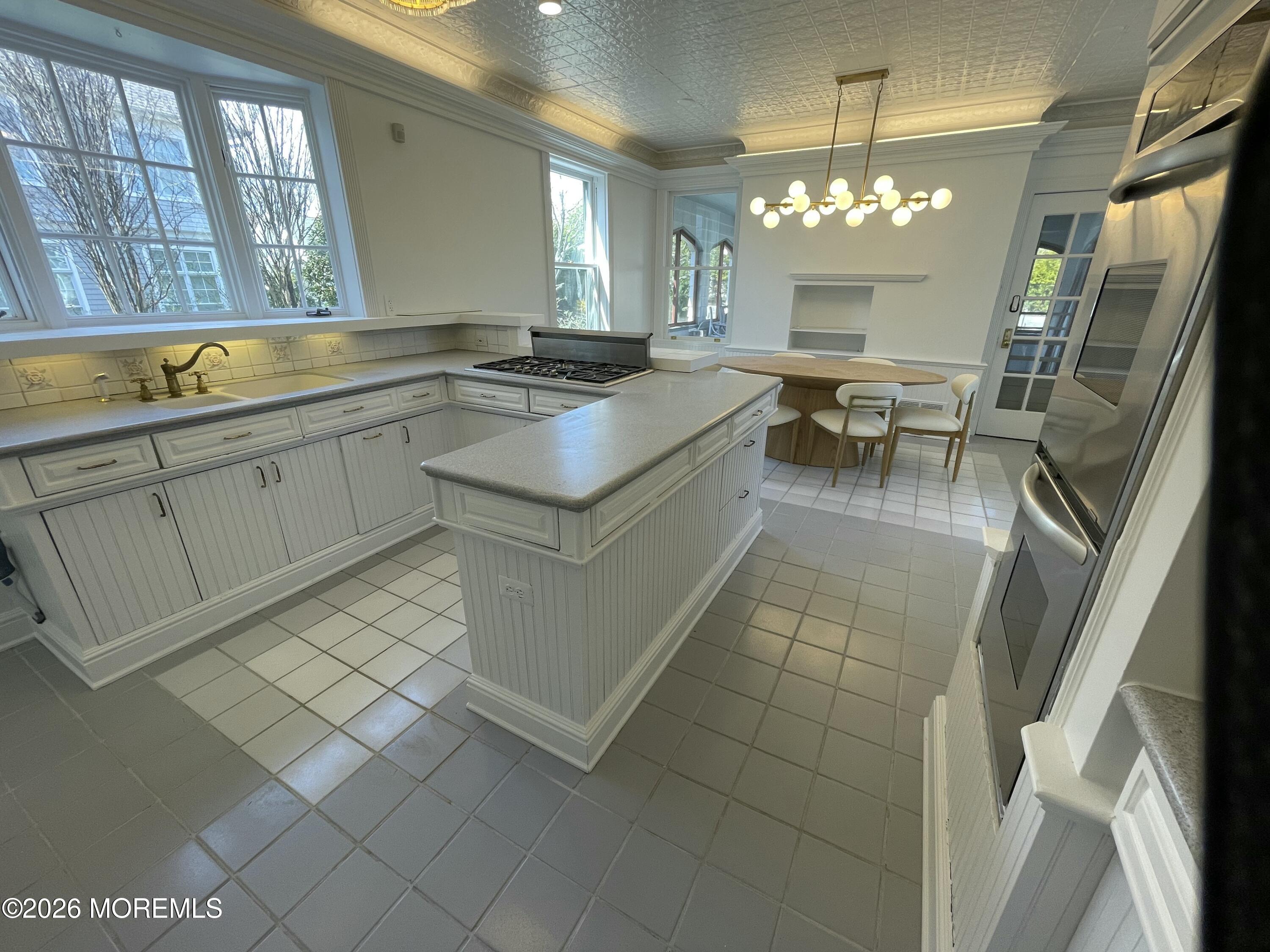 211 Cedar Avenue Allenhurst, NJ 07711 - Photo 14 of 20 a large white kitchen with a sink and dishwasher a stove with wooden floor