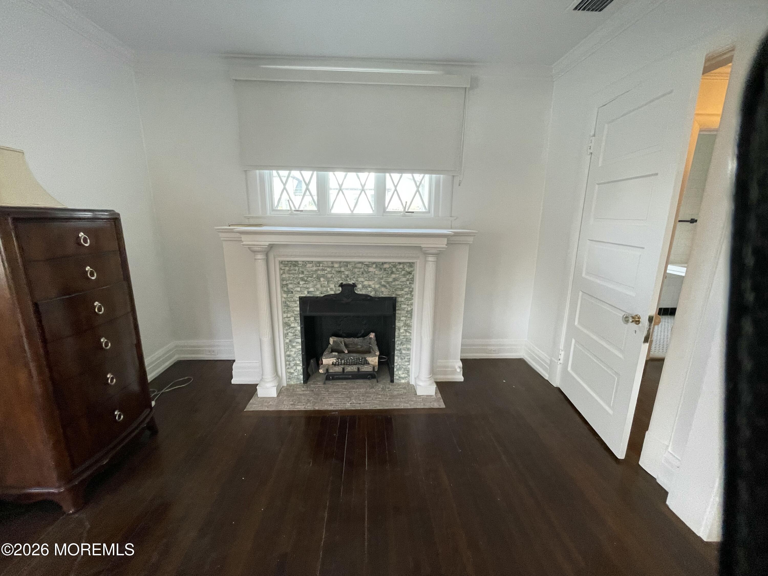 211 Cedar Avenue Allenhurst, NJ 07711 - Photo 20 of 20 a view of an empty room with wooden floor and a fireplace