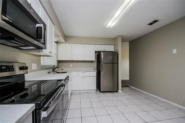 a kitchen with a refrigerator and a stove top oven
