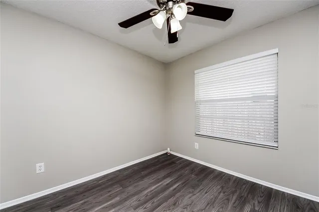 an empty room with a window and a fan