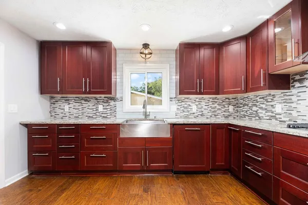 a kitchen with stainless steel appliances granite countertop a stove a sink and a refrigerator