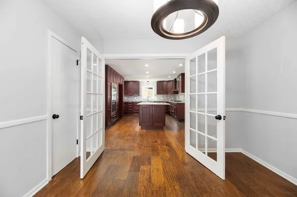 a view of a big room with wooden floor and windows