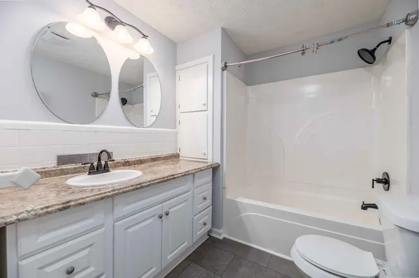 an empty room with ceiling fan and window