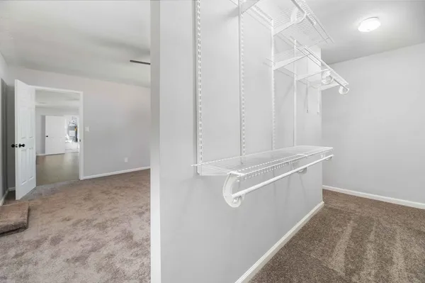 a view of empty room with wooden floor and ceiling fan