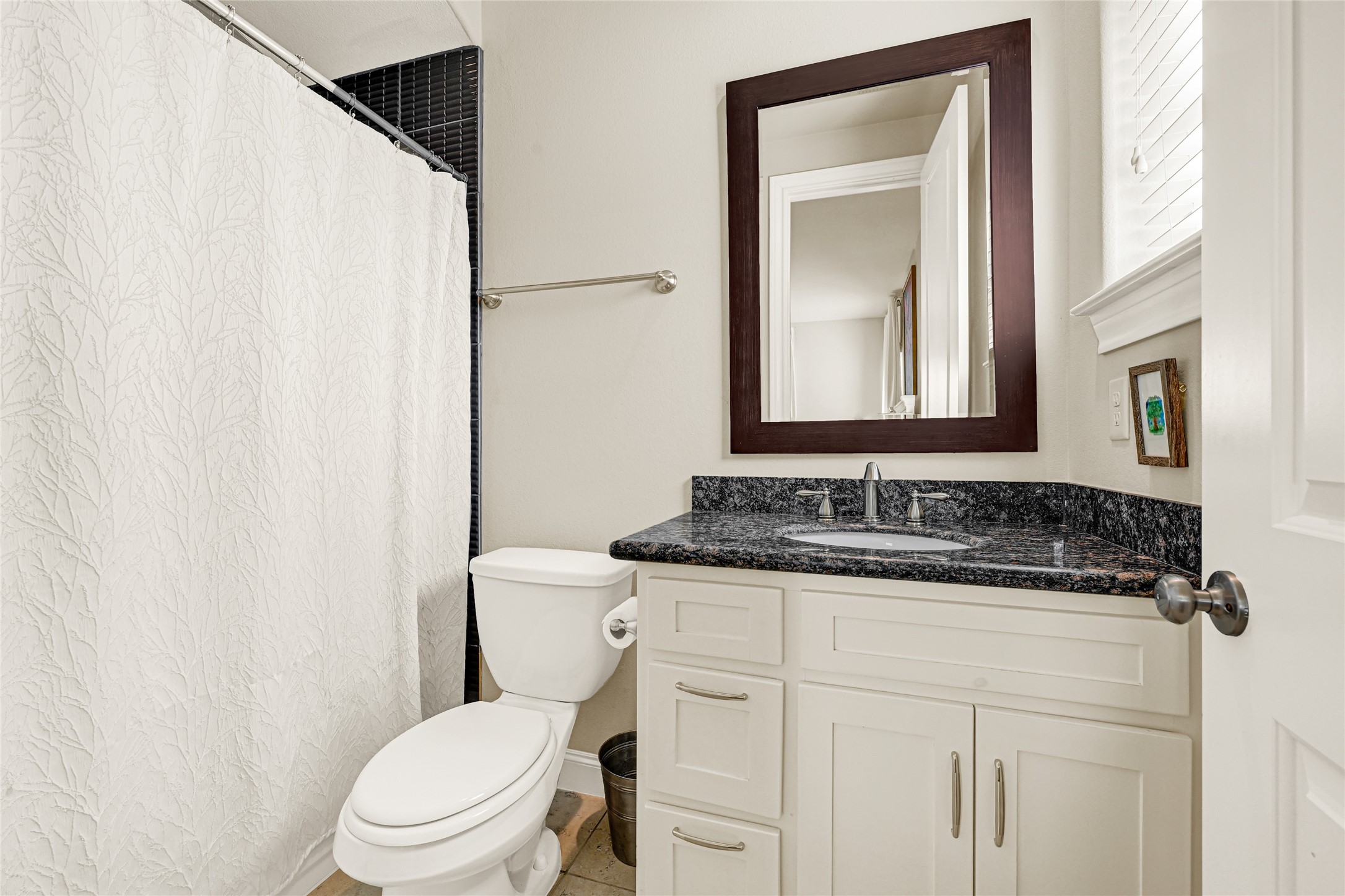 2039 Fannin Station North Houston, TX 77045 - Photo 11 of 25 a bathroom with a granite countertop sink vanity mirror and toilet