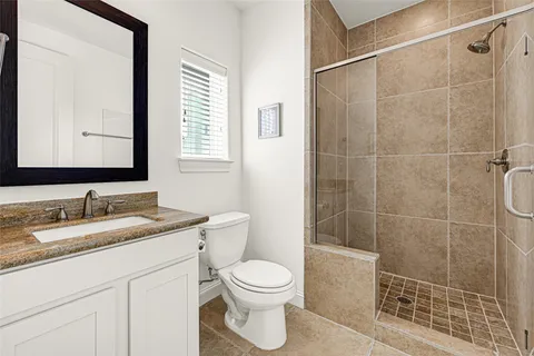 a bathroom with a granite countertop sink toilet a mirror and shower