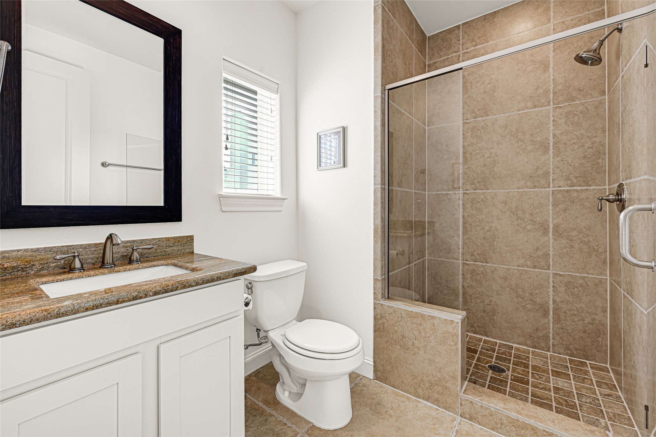 2039 Fannin Station North Houston, TX 77045 - Photo 13 of 25 a bathroom with a granite countertop sink toilet a mirror and shower
