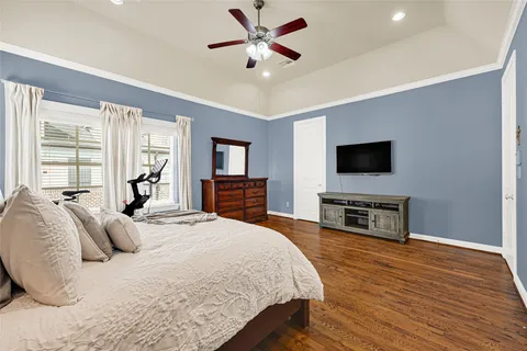 a spacious bedroom with a bed and a flat screen tv