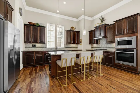 a kitchen with stainless steel appliances a stove a sink island and a refrigerator