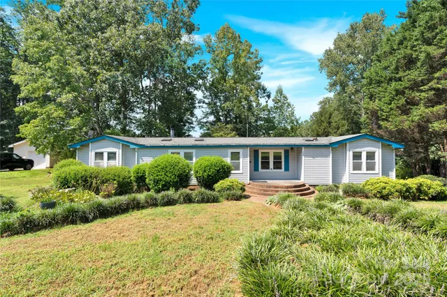 a front view of a house with a yard and trees