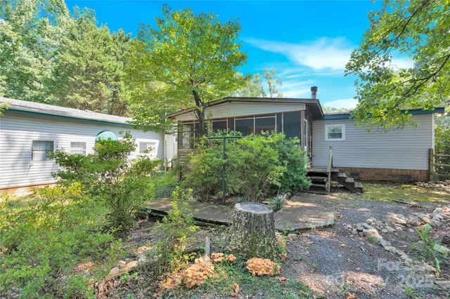 a view of a small yard with plants and a barbeque