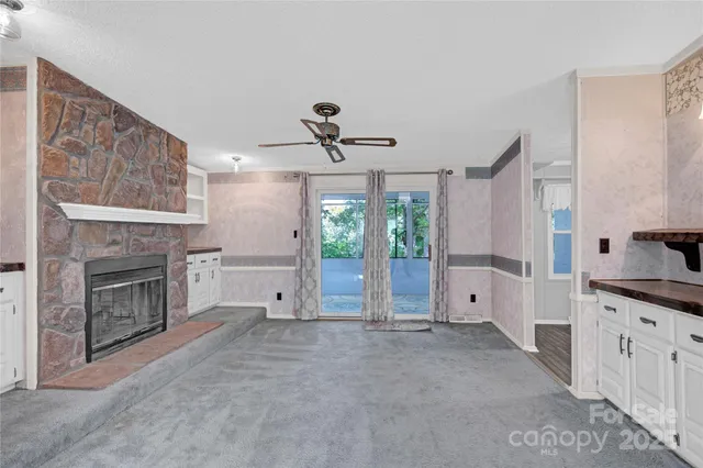 a view of a livingroom with a fireplace and window