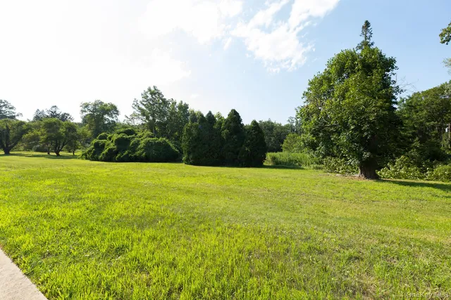 a view of a green field with wooden fence