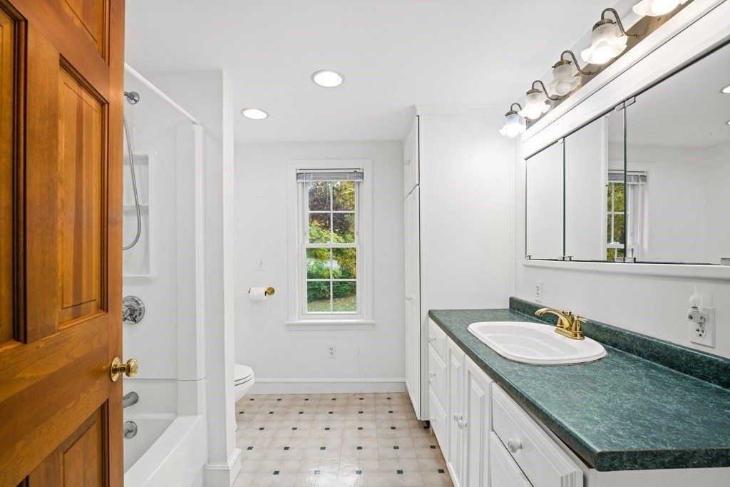 3 Howe Street Ashland, MA 01721 - Photo 21 of 37 a bathroom with a granite countertop sink a mirror a vanity and a shower