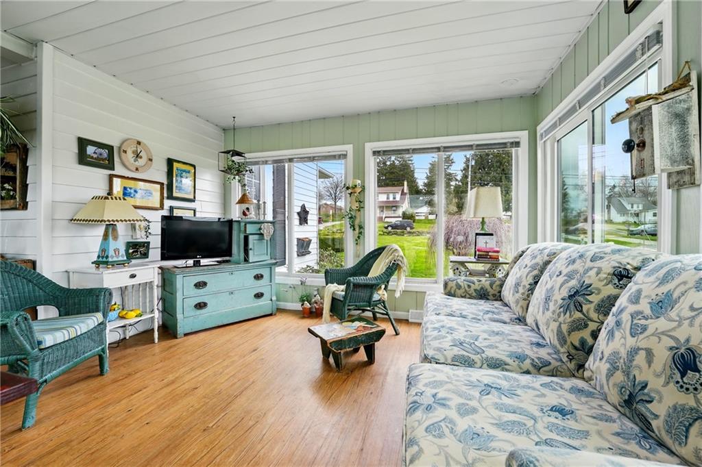 397 Evans City Road Butler, PA 16001 - Photo 11 of 50 a living room with furniture floor to ceiling window hardwood floor and a flat screen tv