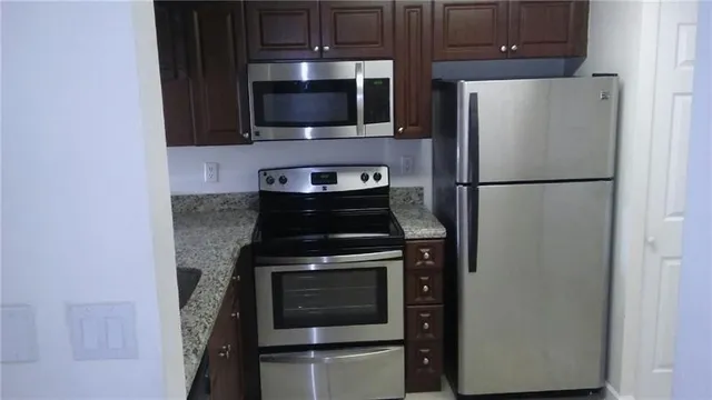 a white refrigerator freezer and a stove sitting inside of a kitchen