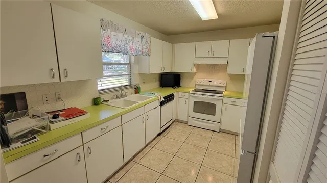 a kitchen with a sink a stove and cabinets