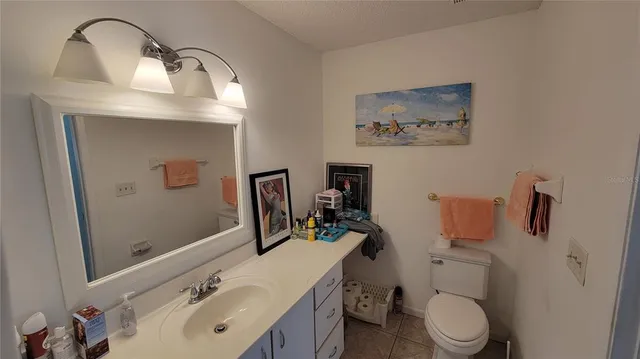 a bathroom with a sink vanity mirror and toilet