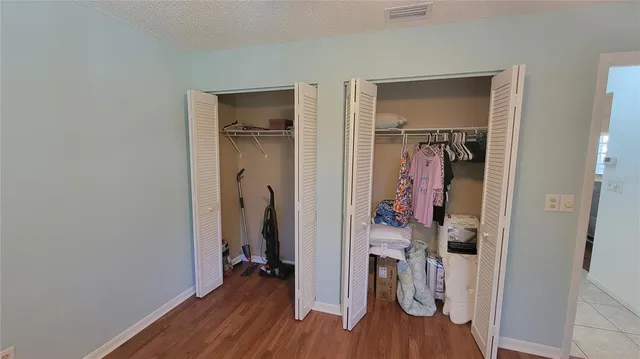 a view of a hallway with wooden floor and closet