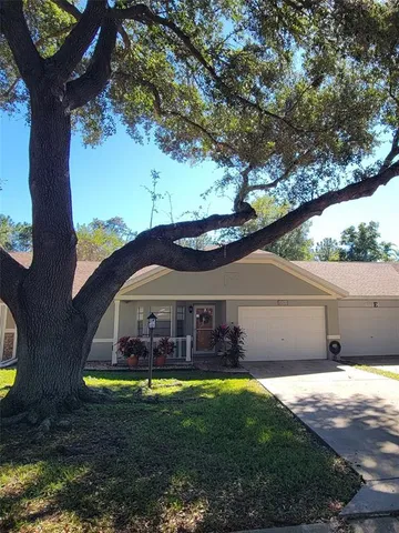 a view of a big house with a big yard and large tree